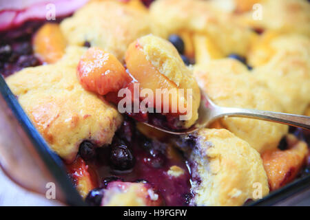 A serving spoon of fresh fruit cobbler with cinnamon Stock Photo