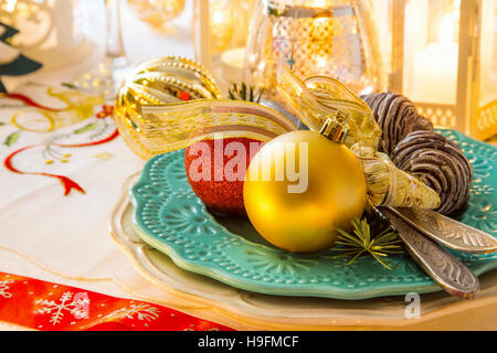 Christmas table setting with festive decorations,Christmas balls, pine cones, ribbon and candle lights Stock Photo