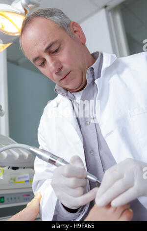 podiatrist working on a patient in a clinic Stock Photo