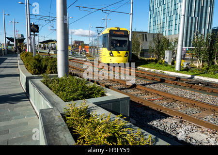 Tram, flower beds and landscaping at the Deansgate-Castlefield tram stop, Manchester, England, UK. Stock Photo