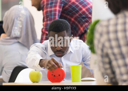 Worried young African man in formalwear checking time while look Stock Photo