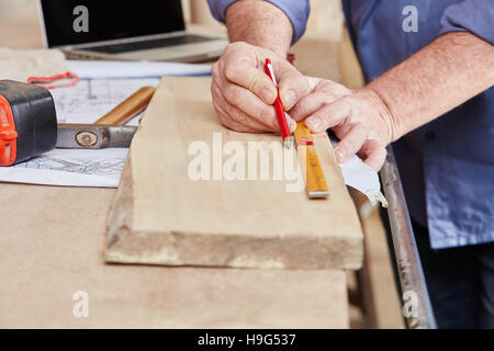 Carpenter measuring wood board with pen and ruler Stock Photo