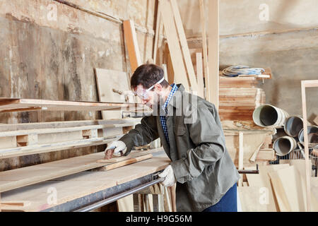 Carpenter working with grinder at carpentry workshop Stock Photo