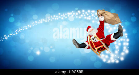 crazy santa claus on his sleigh hilarious fast funny crazy xmas christmas gift present delivery blue wide panorama bokeh background Stock Photo