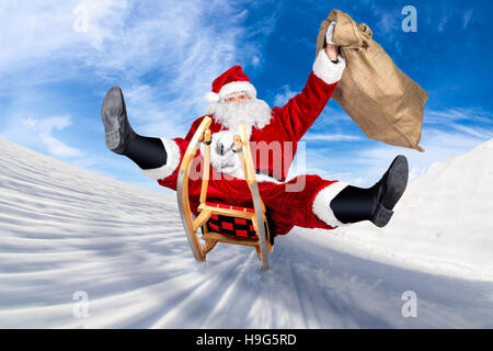 crazy santa claus on his sleigh hilarious fast funny crazy xmas christmas gift present delivery blue sky background Stock Photo