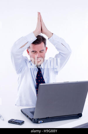 Businessman doing yoga at work Stock Photo