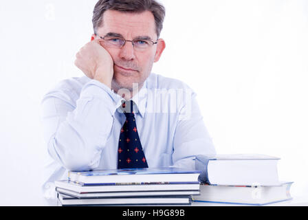 Man, 50+, leaning on a stack of books Stock Photo