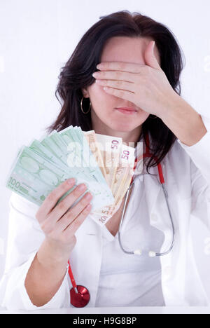 Doctor holding banknotes, symbolic picture for hush money Stock Photo