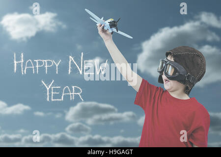 Composite image of boy playing with toy airplane Stock Photo