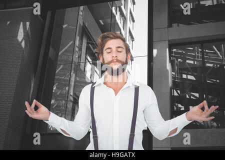 Composite image of hipster meditating arms outstretched Stock Photo