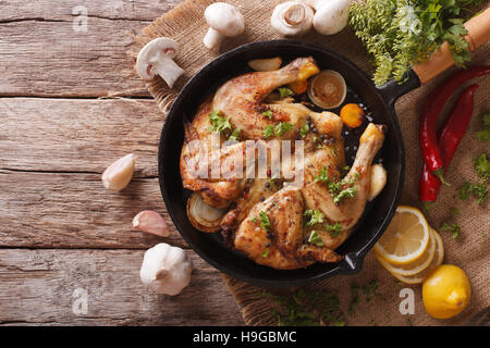 Hot Fried Chicken tobacco with herbs and garlic in a pan close-up. horizontal view from above Stock Photo