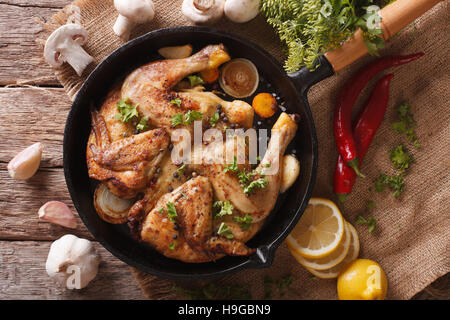 Hot Fried Chicken Tabaka with ingredients close-up on the table. horizontal view from above Stock Photo