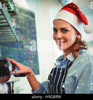 Composite image of portrait of waitress using coffee maker at cafeteria during christmas Stock Photo