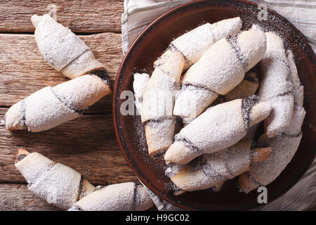 Freshly baked crescent with poppy stuffing close-up on a plate on the table. horizontal view from above Stock Photo