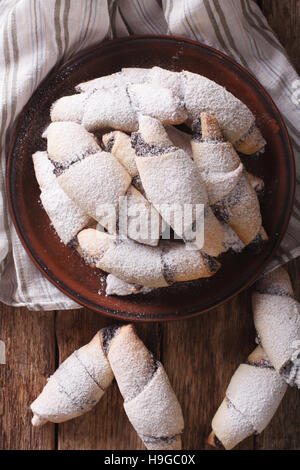 Freshly baked crescent with poppy stuffing close-up on a plate on the table. vertical view from above Stock Photo