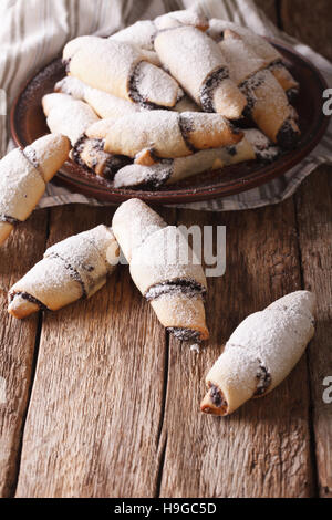 Freshly baked crescent with poppy stuffing close-up on a plate on the table. vertical Stock Photo