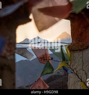 Mountain sunset thorugh a windows of buddhist flags. Stock Photo