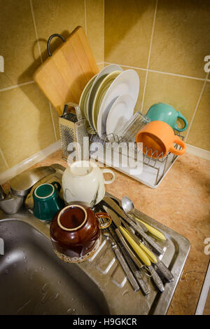 Dishes, cups, glasses, plates, forks, knives and spoons are drying ...