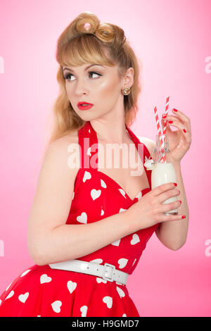 Pin Up girl drinking milk from a retro bottle with straws Stock Photo