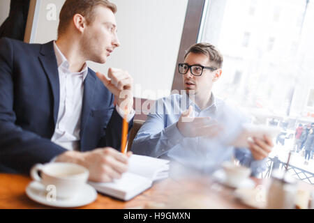 Two young managers discussing work and ideas Stock Photo