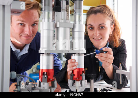 Engineer And Apprentice Working On Machine In Factory Stock Photo