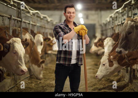 Young agricultural worker posing in a cowshed Stock Photo