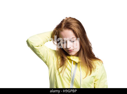 Teenage girl in yellow running jacket. Studio shot, isolated. Stock Photo
