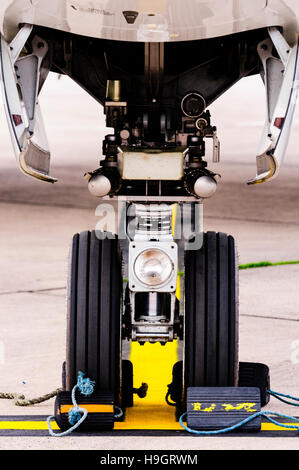 Nose wheel of a Boeing 737 with chocks to prevent movement. Stock Photo