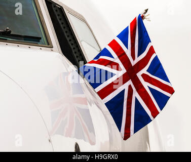 Pilot of a 737 on a diplomatic flight flies a Union Flag from the cockpit window. Stock Photo