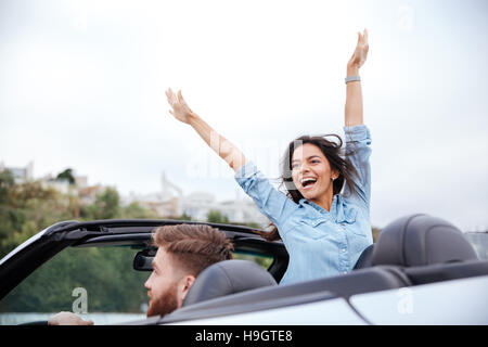 Young couple in love on road trip driving in convertible car Stock Photo