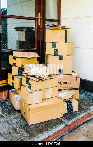 Amazon, Amazon Prime, and Amazon Pantry boxes on the front step of a house after being delivered. Stock Photo