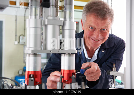 Portrait Of Male Engineer Working On Machine In Factory Stock Photo
