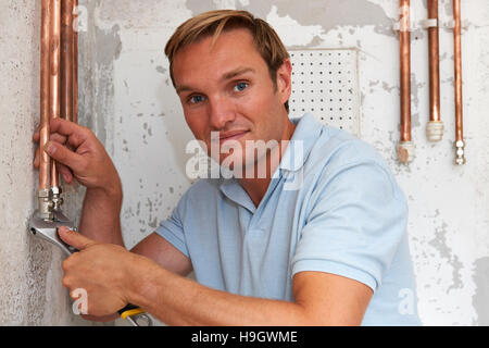 Plumber Working On Pipes At Construction Site Stock Photo