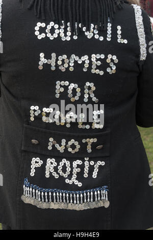 London, UK. A housing campaigner in pearly costume with the message 'Council Homes for People Not Pro£it' spelt out in buttons on her back at the Axe the Housing Act at a rally opposite parliament as the Chancellor announced his Autumn Statement. They say the Act is fundamentally unfair and will worsen the housing crisis and call on it to be repealed, and for tenants groups, trade unions, councils and housing associations to work together to resist and defeat it. Peter Marshall/Alamy Live News Stock Photo