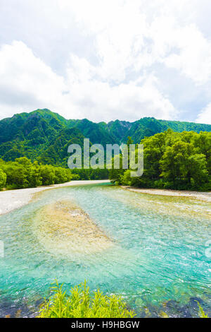 Mountains and crystal clear Azusa River in this pristine and untouched nature landscape in Japanese Alps town of Kamikochi Stock Photo