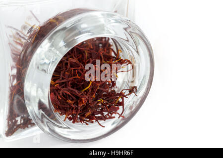 close up image of Saffron in a thick glass jar on a white background, copy space to the right Stock Photo