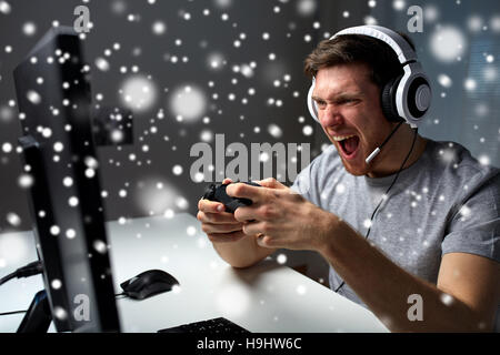 man in headset playing computer video game at home Stock Photo