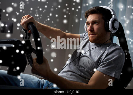 man playing car racing video game at home Stock Photo