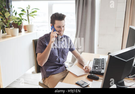 happy creative male worker calling on smarphone Stock Photo