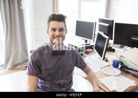 happy creative male office worker with computers Stock Photo