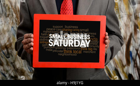 Professional holding Small Business Saturday Sign in Hand. Stock Photo