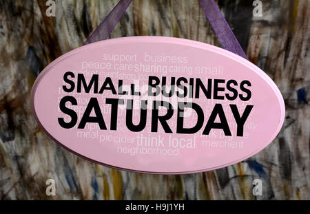 Small Business Saturday Sign hanging on Pink Sign. Stock Photo
