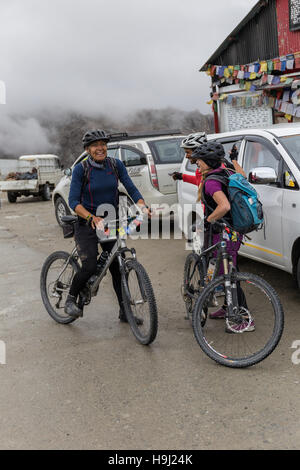 Two female cyclists are congratulated on cycling to the top of Khardungla Pass Stock Photo