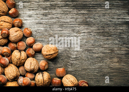 Whole walnuts and hazelnuts on a wooden background Stock Photo