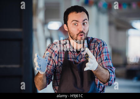 Worker show his finger in cloth glove explaining something to someone Stock Photo