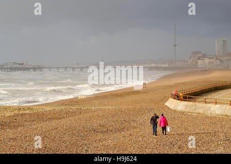 Brighton 22 Nov 2016: Two people brave Brighton Beach just after Storm Angus has passed through, Stock Photo