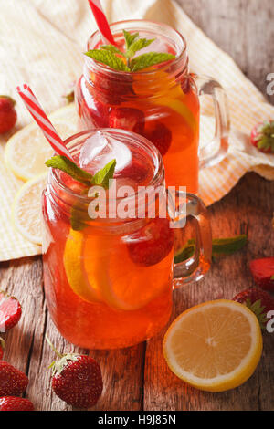 Summer strawberry lemonade with peppermint close-up in a glass jar on the table. Vertical Stock Photo