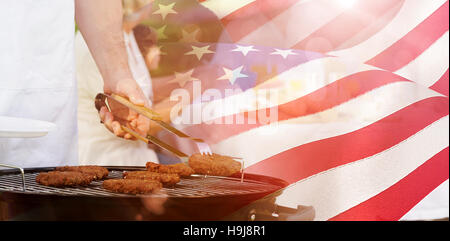 Composite image of barbecue grill with extended family having lunch in park Stock Photo