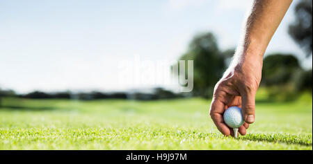 Golfer placing golf ball on tee Stock Photo