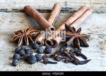 Ingredients for cooking Masala chai or mulled wine with spices on wooden background for winter and Christmas. Food still life. Vintage stylized Stock Photo